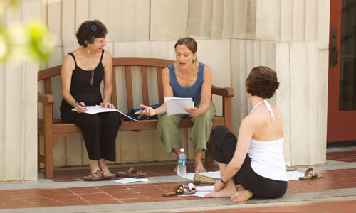 photo of three older than average TWU students studying together on the porch of one of classic buildings on campus