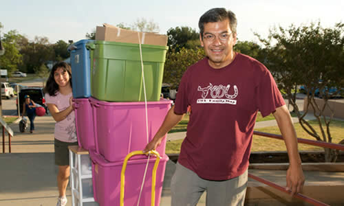 photo of a TWU father and daughter moving in to the dorm on Move In Day