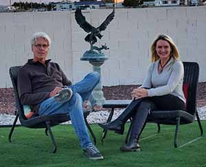 Jody and David Popple sitting by a sculpture