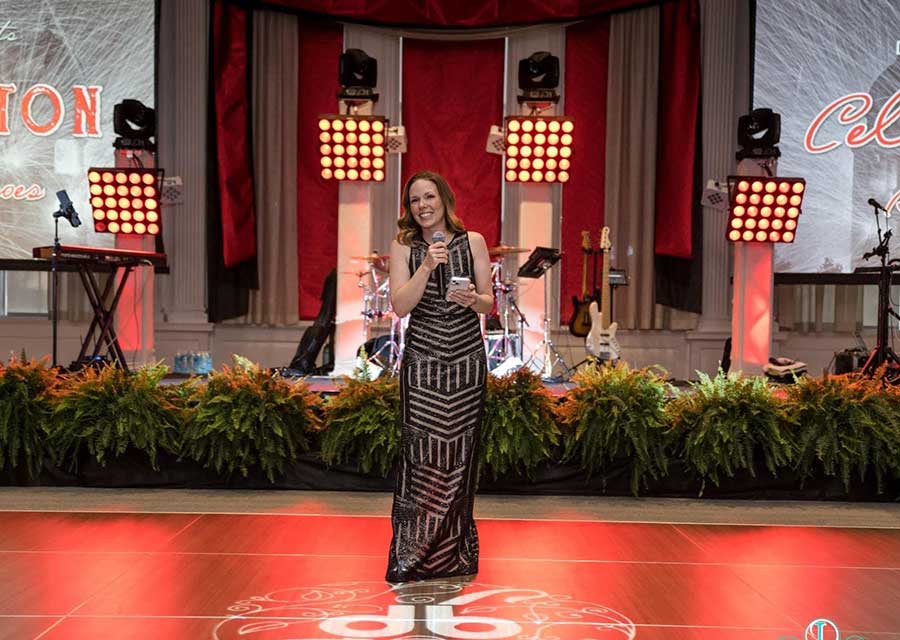 woman stands with microphone on dance floor