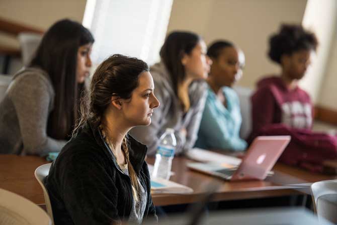 A group of women sit in a classroom setting.