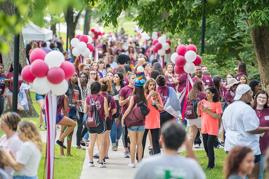 Students wearing maroon walking across TWU's Denton campus.