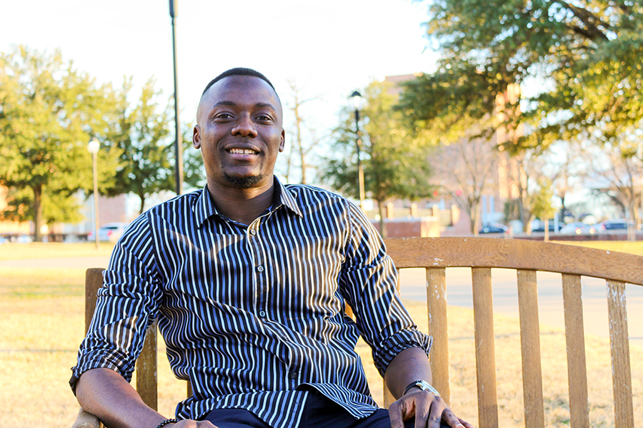 Alexander sitting on a bench on campus.