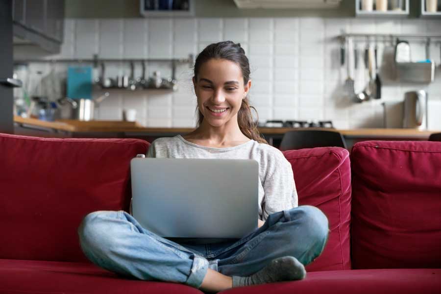 A woman works on a laptop in her living room.