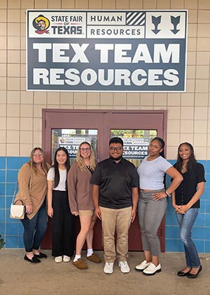 Amanda Stafford (third from left) stands with six colleagues underneath a Tex Team Resources sign