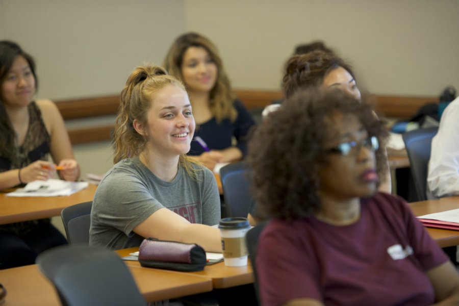 A group of students sitting in class	