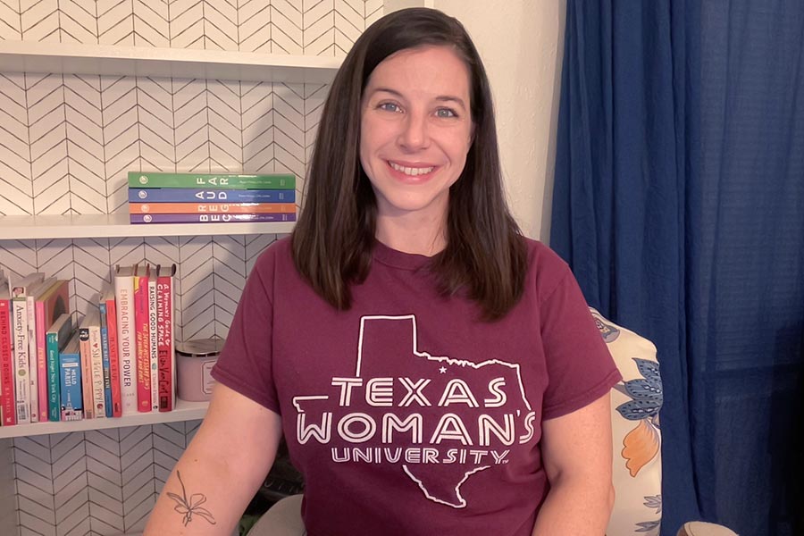 student sits on chair wearing maroon TWU shirt