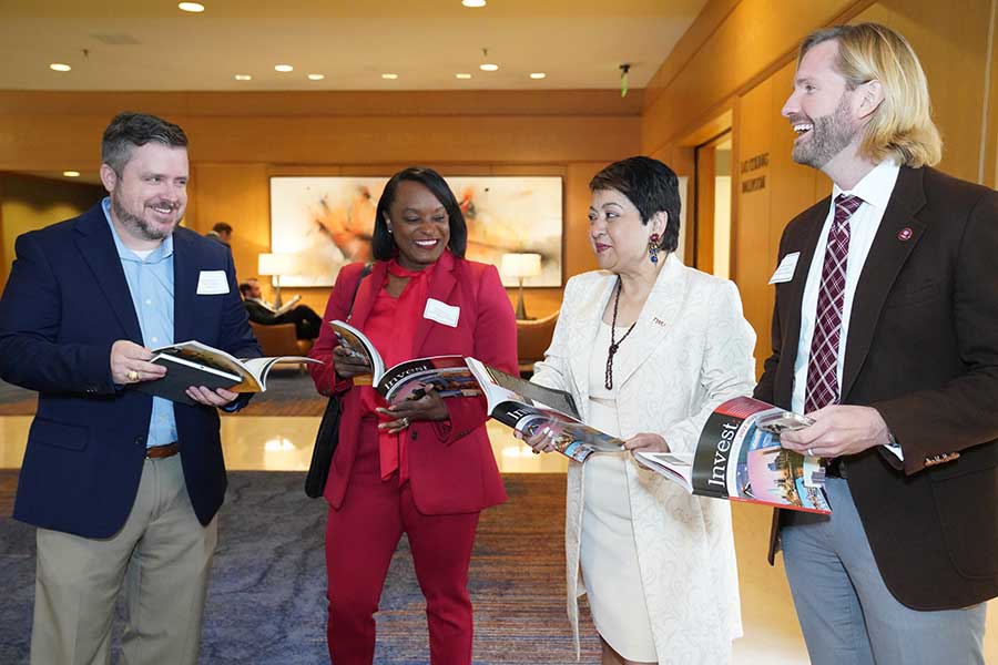 four TWU staff members look at catalogs in hallway 