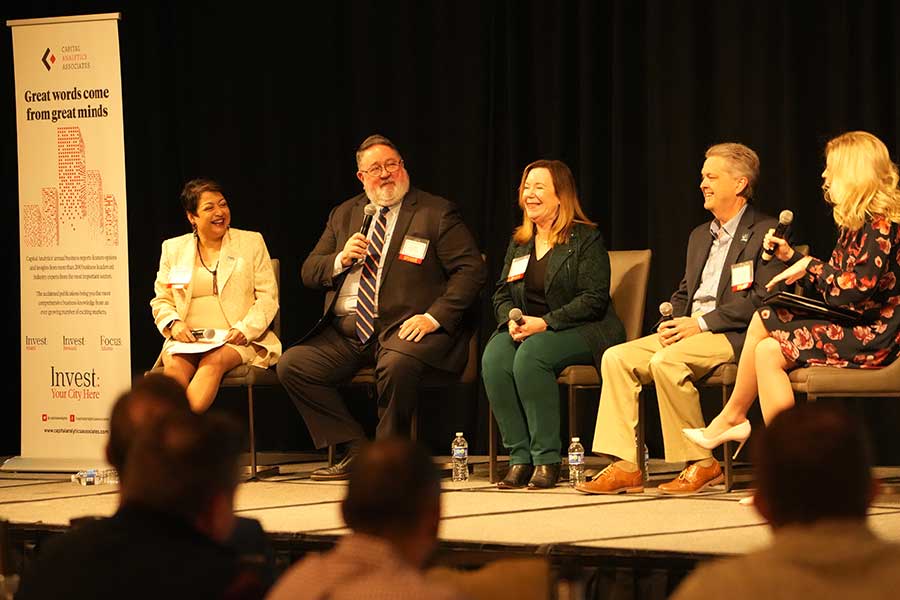 Dean Yelkur sits on stage with four other panelists