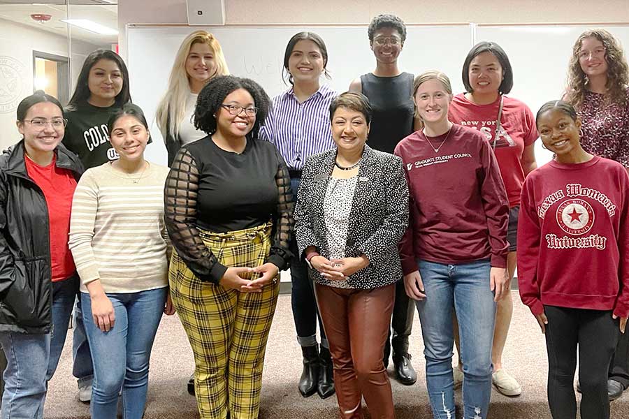 Dean Yelkur stands in classroom alongside 11 students 