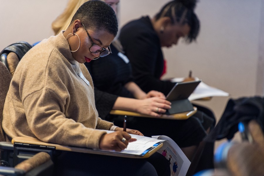 An MSA student sitting in a classroom reading a textbook.