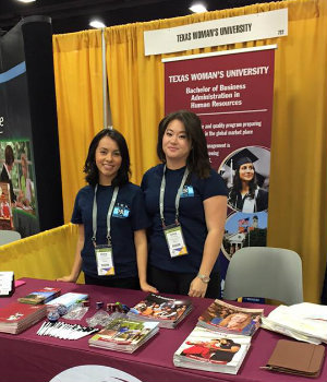 Two SHRM members at a conference with TWU banners behind them.