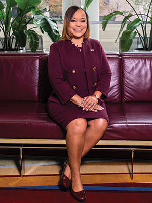 Portrait of Dr. Williams sitting on a maroon couch.