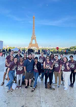 a group of students from study abroad trip stand in front of the Eiffel Tower