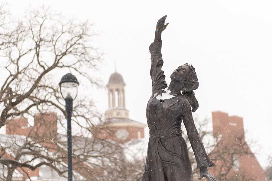 TWU's library and a statue covered in snow.