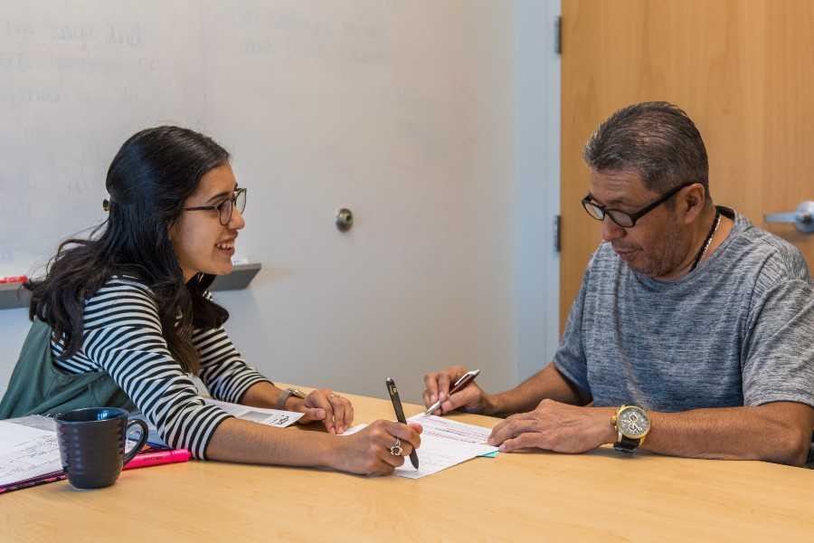 A TWU Stroke Center clinical student working with a stoke patient at a table in an office.