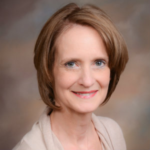 A portrait of Charlene Dickinson smiling.