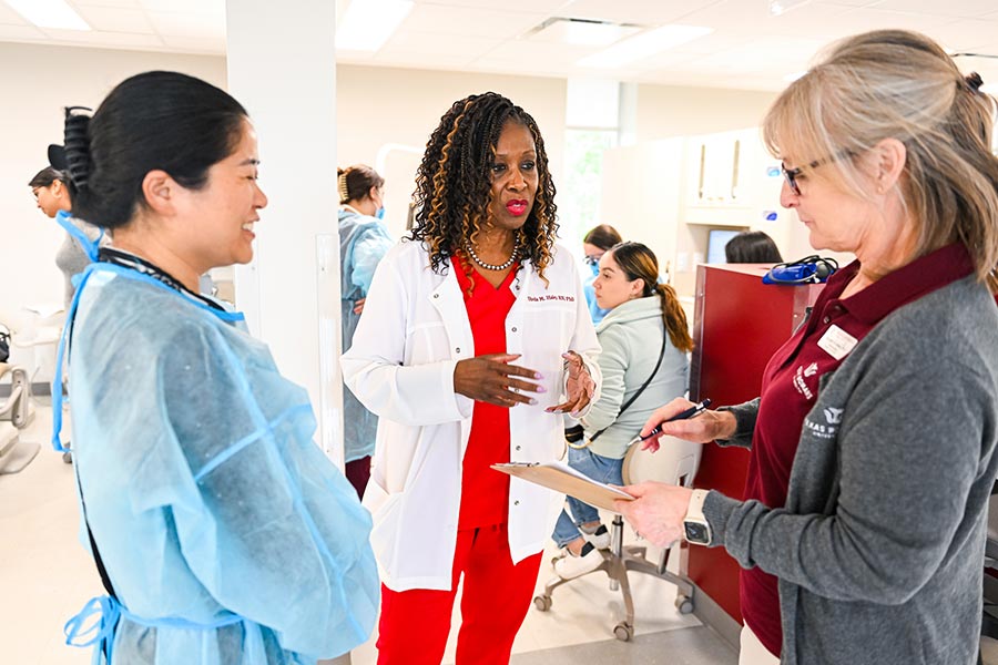 three staff memebers stand in a circle in a dental hygiene clinic