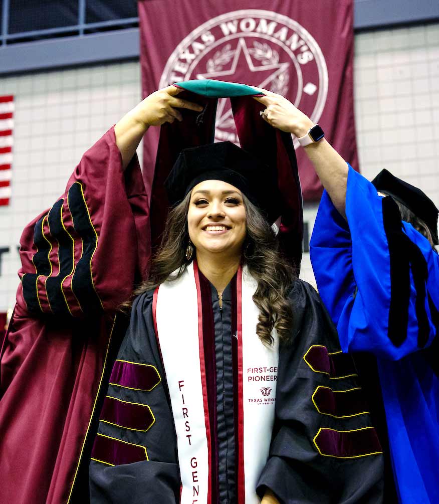 First-generation student being hooded at graduation