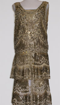 A dress with a tubular silhouette, short skirt, hip waistline. Made of a sequined pale grey chiffon.