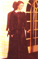 The black silk dress has bell sleeves and a collar and cuffs of lace.