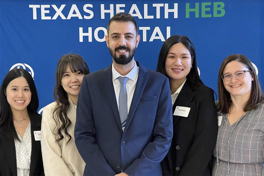 five MHA students stand in front of blue back drop 