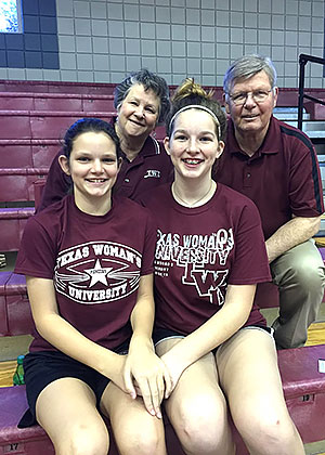 two young sisters sit on a bleacher in front of grandparents