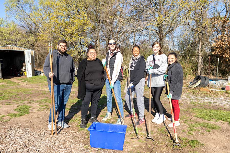 six students hold shovels at park
