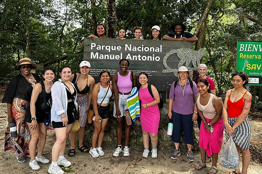  students stand in front of and on top of a Manuel Antonio National Park