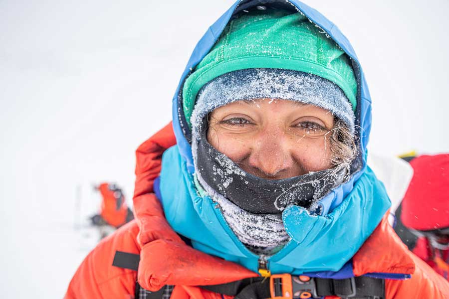 A selfie of Roxanne Gonzales-Vogel on a snowy mountain in Antarctica and wrapped in climbing and protective gear.