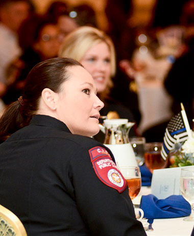 A female police officer sitting a table looking to the right