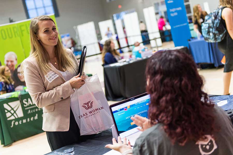 A TWU student at a booth at the career and internship fair.