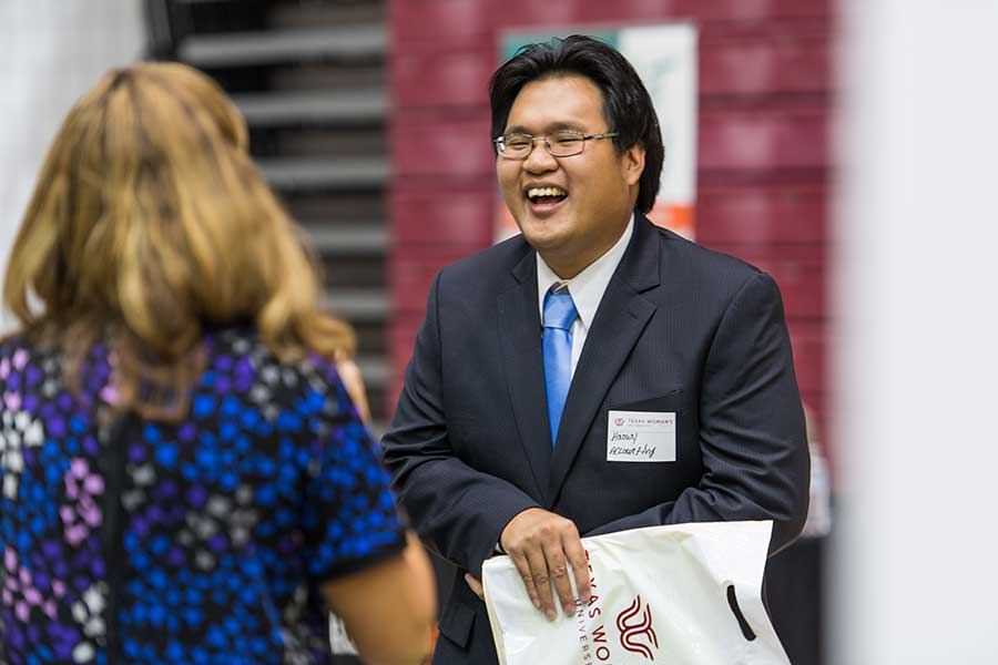 A TWU student talks with an employer at an internship and career fair.