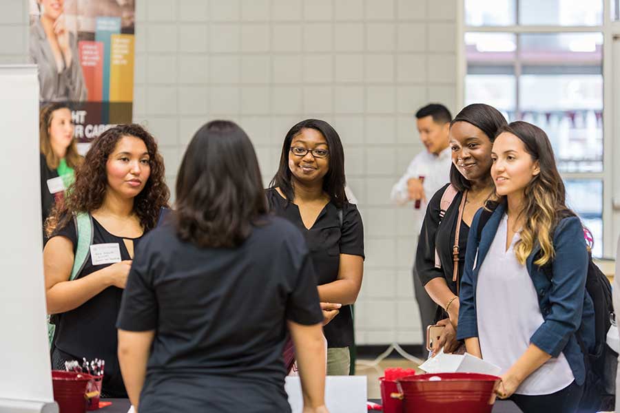 A group of TWU students speaks to an employer on campus.