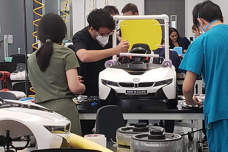 three students work on  mini-robotic car