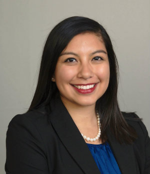 A portrait of Adriana Blanco smiling while dressed in business professional clothes.