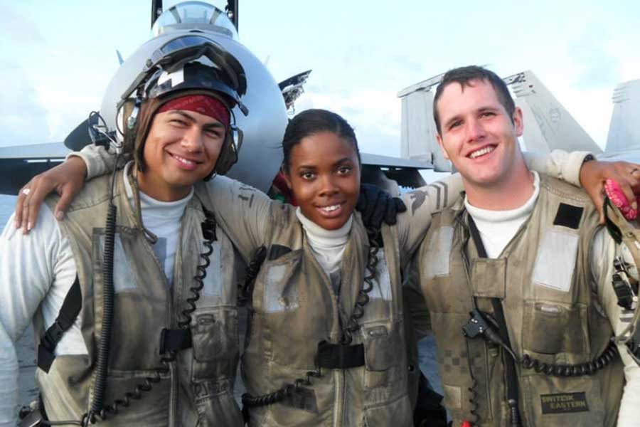 Chanel VanHook with two military friends all in uniform on a sunny day with military planes in the background.