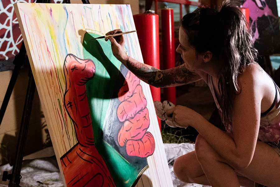 Katie Mont works on a painting in a studio setting.