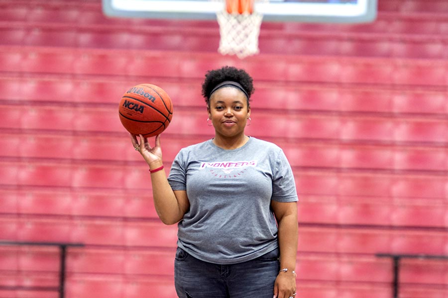 TWU student holds a basketball in gym