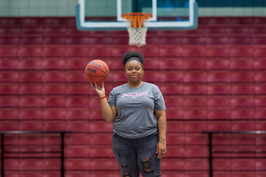 TWU student holds a basketball in gym