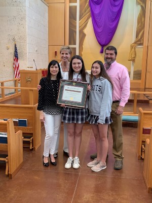 Celia Nowlin poses with her award, Chancellor Feyten and her parents.