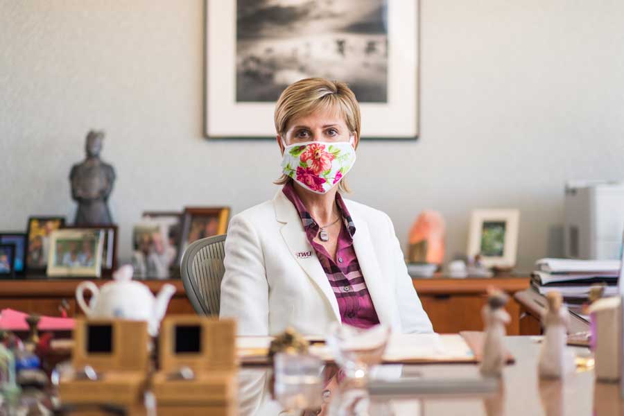 Chancellor Carine Feyten wearing a face mask while sitting in her office.