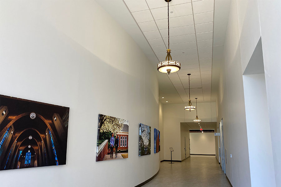 Vintage light fixtures hang down a modern hallway in TWU's renovated Hubbard Hall.