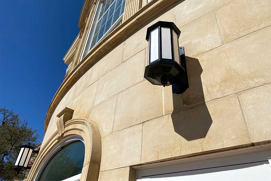 Vintage light fixtures hang on the outside wall of TWU's renovated Hubbard Hall.