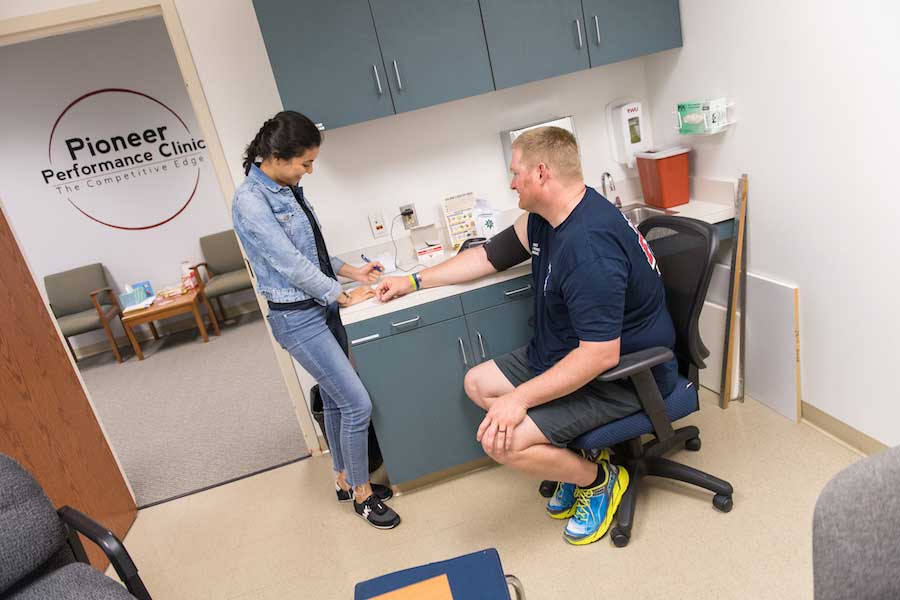 TWU student takes blood pressure of Denton firefighter during wellness testing