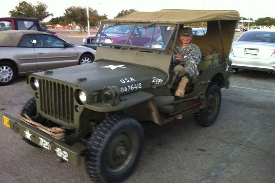 Lisa Bass in a military vehicle and camo.