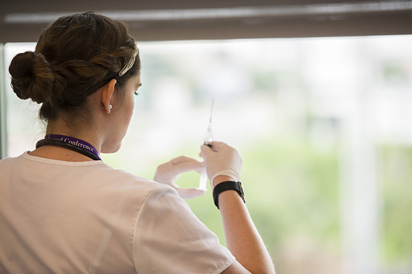 Nursing student holding syringe