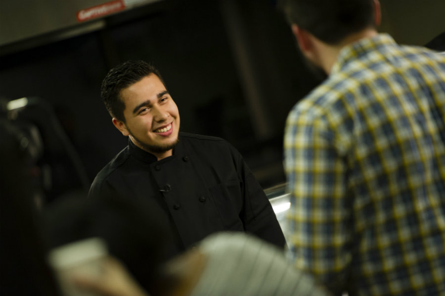 Walter Rivas in his chef uniform being interviewed.