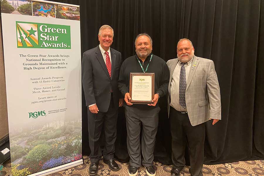 Roberto Trevino, TWU’s manager of landscape operations, is flanked by Mark Feist (left), chairman of the Professional Grounds Management Society’s Awards Committee and Joe Kovolyan, the organization’s president.