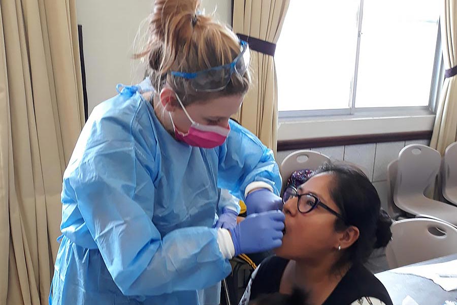 A TWU student practices dental hygiene on a patient in a low-income community in Peru.